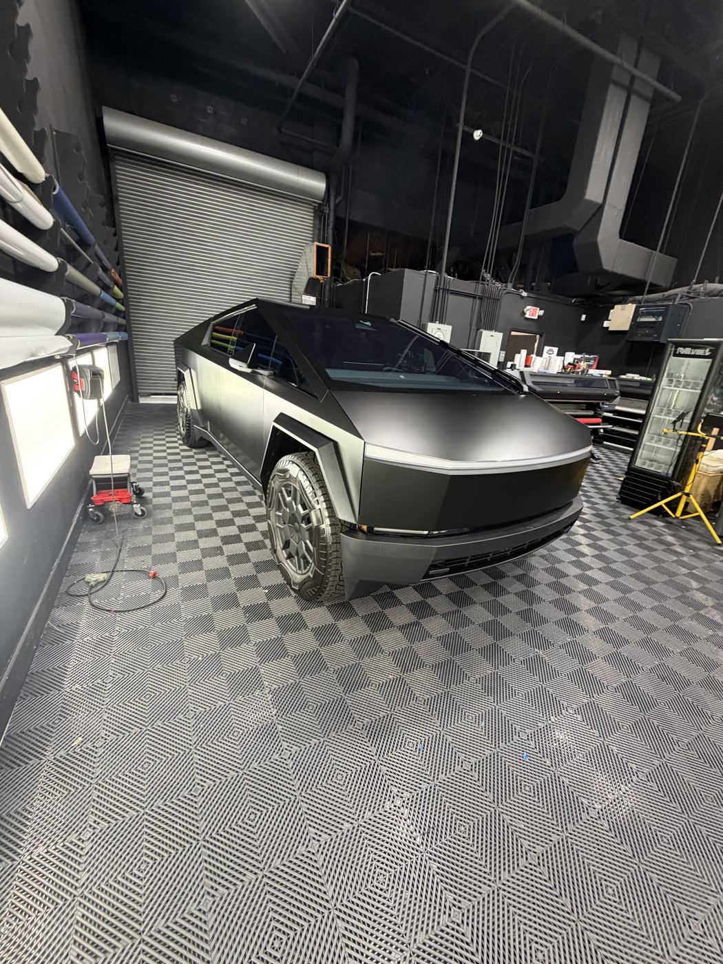 Tesla Cybertruck envuelto en vinilo negro satinado dentro del taller