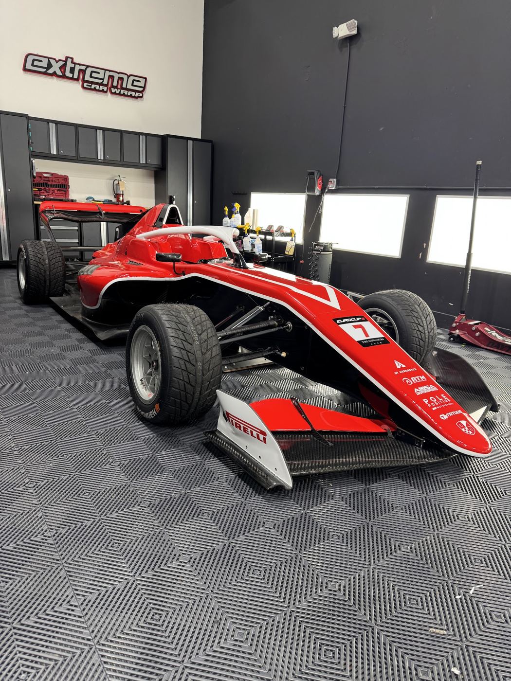 Auto de Fórmula 4 con gráficos rojos y blancos